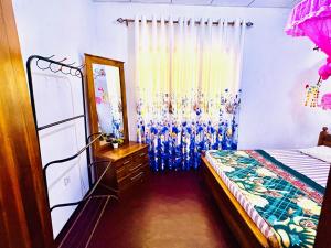 a bedroom with a bed and a dresser and a mirror at Oli Guest House Diyatalawa in Diyatalawa