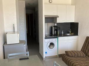 a kitchen with a washing machine and a washer at SETE studio cabine face mer in Rémire-Camp