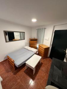a bedroom with a bed and a table and a mirror at Apartamento La Línea 3 in La Línea de la Concepción