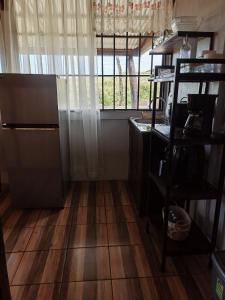 a room with a wooden floor and a window at Hospedaje La Guaca in Bagaces