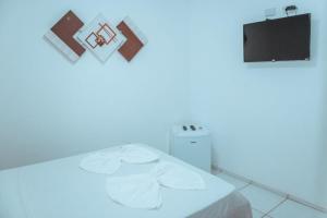 a white room with a bed and a tv at Pousada Zayon Jeri in Jericoacoara