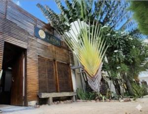 a building with a palm tree in front of it at Pousada Zayon Jeri in Jericoacoara