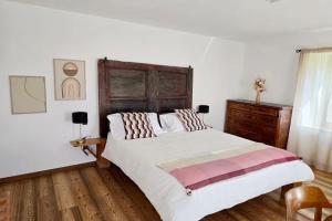 a bedroom with a large bed with a wooden headboard at Maso Sasso - La Locanda di Putipù in Villa Lagarina