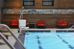 a swimming pool with red chairs and a pool at The Palmer House Hilton in Chicago