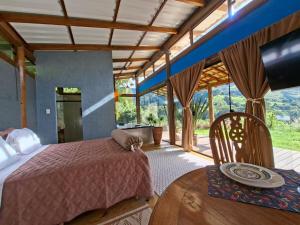 a bedroom with a bed and a table at Loft Pitangueira in Petrópolis