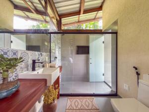 a bathroom with a sink and a glass shower at Loft Pitangueira in Petrópolis