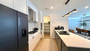 a kitchen with black appliances and a dining room at Binshaw Main House in Glenlee Station