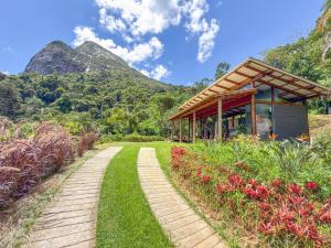 a path leading to a building with mountains in the background at Loft Pitangueira in Petrópolis