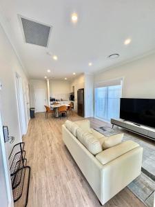 a living room with a couch and a flat screen tv at Binshaw Main House in Glenlee Station
