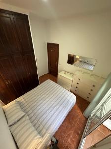 a small bedroom with a bed and a mirror at Apartamento La Línea 1 in La Línea de la Concepción