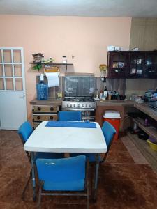 eine Küche mit einem weißen Tisch und blauen Stühlen in der Unterkunft Seidy del Mar in Telchac + 10 Fotos