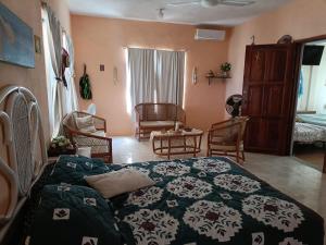 ein Schlafzimmer mit einem Bett und Stühlen in einem Zimmer in der Unterkunft Seidy del Mar in Telchac