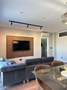 a living room with a couch and a flat screen tv at Brisa de Sálvora in Ribeira