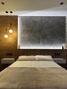 a bedroom with a large bed with two lights at Brisa de Sálvora in Ribeira