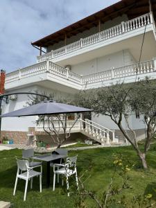 a table and chairs with an umbrella in front of a building at Visi Villa Berat in Berat