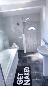 a bathroom with a tub and a sink and a door at Bright Housing in Gateshead +30 photos