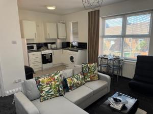 a living room with a couch and a kitchen at Bright Housing in Gateshead