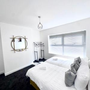 a white bedroom with a bed and a window at Bright Housing in Gateshead