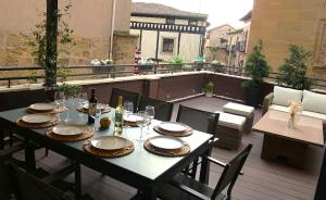 ein Tisch mit Tellern und Gläsern auf einem Balkon in der Unterkunft Edificio Privado con Terraza in Haro