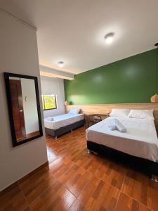 a large room with two beds and a mirror at Amazon Garden Suites - Recojo del aeropuerto incluido in Pucallpa