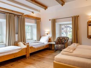 a bedroom with two beds and a chair at Biber Art Apartment 1 Small in Biberwier
