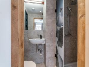 a bathroom with a sink and a toilet and a mirror at Biber Art Apartment 2 Small in Biberwier +13 photos