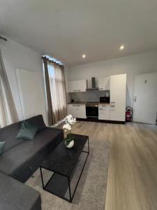 a living room with a couch and a table at Stylish 1BR Apartment Close to City Center Liège in Liège +5 photos