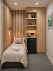 a bedroom with a bed and a small cabinet at Tauranga Backpackers - Private Guest Rooms by the Water! in Tauranga