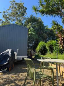 a picnic table and chairs next to a trailer at Tiny Escape in Lennox Head
