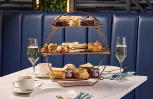 a table with a tray of pastries and glasses of wine at Hilton Cobham in Cobham +103 photos