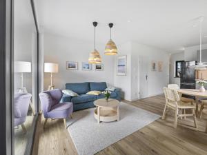 a living room with a blue couch and a table at Schulzenhufe an der Ostsee in Beckerwitz