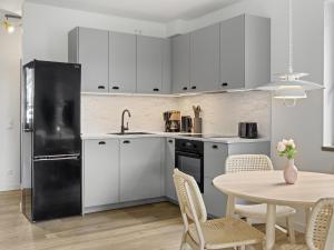 a kitchen with a black refrigerator and a table at Schulzenhufe an der Ostsee in Beckerwitz