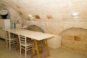 a dining room with a table and a stone wall at La Torre e il Mare - Room 3 by StHey in Monopoli