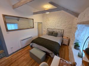 a bedroom with a large bed and a mirror at Postmasters House in Helston