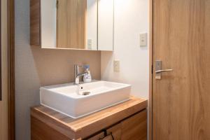 a bathroom with a white sink and a mirror at House Of Joy Furano -15 mins to ski resort- in Furano +31 photos
