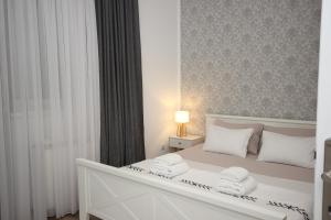 a bedroom with a white bed with two towels on it at Stan na dan Moonlight Panonija in Inđija