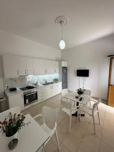 a kitchen with white cabinets and a table and chairs at Visi Villa Berat in Berat