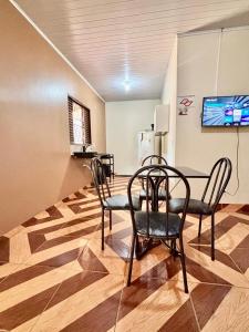 a dining room with chairs and a table and a refrigerator at Sol do Jalapão Kitnets Completas com Ar a 6km do Aeroporto de Palmas in Palmas