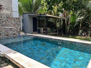 a large blue swimming pool in a yard at Casa Mate y Mar in Punta Leona +1 photo