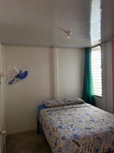 a bedroom with a bed and a fan and a window at Casa Mate y Mar in Punta Leona