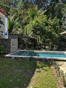 a swimming pool in a yard next to a house at Casa Mate y Mar in Punta Leona