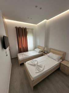 a room with two beds and a tv in it at Visi Villa Berat in Berat