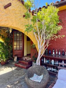 a wicker chair sitting in front of a building with a tree at Hostal El Punto in La Serena