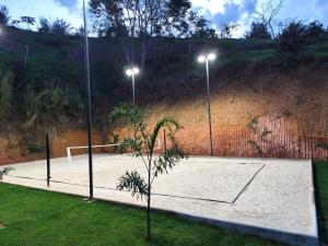 a tennis court with two lights on a hill at Sítio Belo Vale in Cataguases