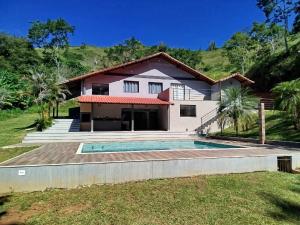 a house with a swimming pool in front of it at Sítio Belo Vale in Cataguases