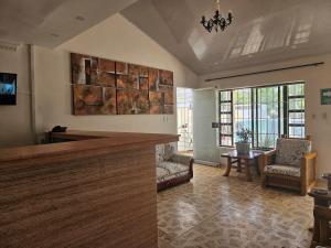 a living room with a bar and a table and chairs at Caribbean Airport Hotel in Cartagena de Indias
