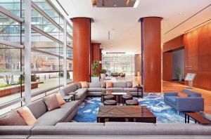 a lobby with couches and tables and large windows at Hilton Baltimore Inner Harbor in Baltimore