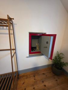 a mirror on the wall in a room with a plant at Postmasters House in Helston