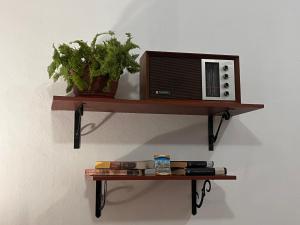 a wooden shelf with a microwave on a wall at HABITACION MODERNA CON PARQUEO y WIFI in Ambato