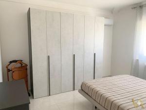 a bedroom with a large white cabinet in a room at VILLA ARCANGELO Lo in Mandatoriccio Marina